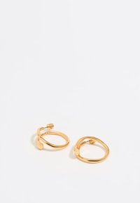 Pendientes de aro color oro con un diseño retorcido, superficie lisa y brillante, y un cierre de poste seguro.