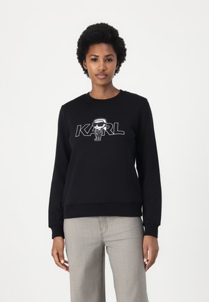 Sweatshirt noir en mélange de coton, avec un imprimé graphique d'un personnage et le mot "KARL". Encolure ras du cou et poignets côtelés avec une coupe décontractée.