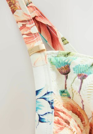 Tessuto a fantasia floreale in colori tenui con un accento dorato sulla tracolla. Il design presenta fiori vivi e una superficie texturizzata.