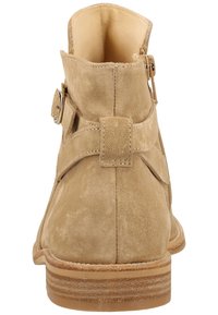 Beige Wildleder-Ankle-Boots mit runder Zehenpartie, seitlichem Schnallen-Detail und niedrigem, gestapeltem Absatz. Glatte Innenauskleidung und sichtbare Nähte.