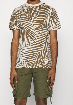 Kurzärmeliges T-Shirt mit weißem Grund und braunem Palmenblattmuster; kombiniert mit olivgrünen Cargo-Shorts.