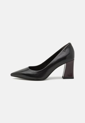 Escarpin noir en cuir verni avec un bout pointu et un talon bloc rectangulaire brillant avec une accentuation bordeaux foncé. Texture lisse.