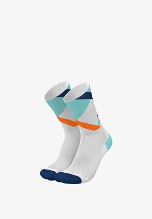 Bunte Knöchelsocken mit einem weißen Grund, pastellfarbenen geometrischen Mustern in Blaugrün und Orange sowie einem navyfarbenen Zehenbereich.