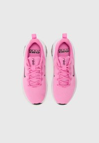 Baskets de sport Nike roses avec une tige en maille, bout rond, col rembourré, fermeture à lacets et une semelle blanche avec un motif texturé.