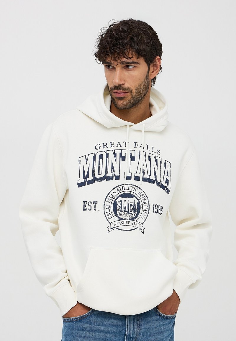 Felpa crema con grafica navy "Montana", tasca frontale e lacci. Vestibilità comoda con polsini e orlo a costine.