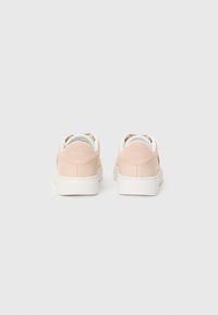 Sneaker in pelle rosa con texture liscia, suole in gomma bianca e accenti a contrasto sul tallone. Design minimalista senza motivi.