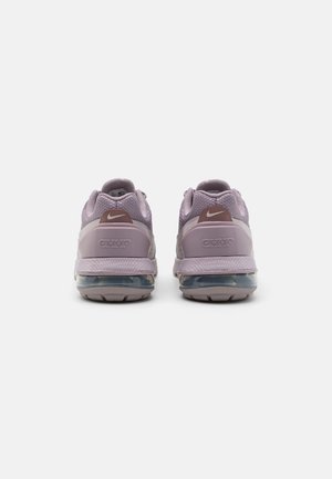 Des chaussures de sport violettes avec des tiges en maille, des cols rembourrés et un amorti en air translucide. Elles présentent des accents bruns et des détails de logo.