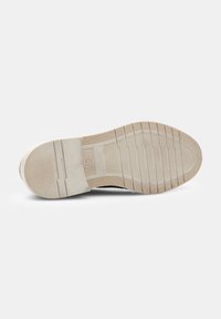 Suela de un zapato con una suela de goma texturizada, que presenta surcos horizontales y verticales, de color beige con un ligero brillo, etiquetada en tamaño 42.