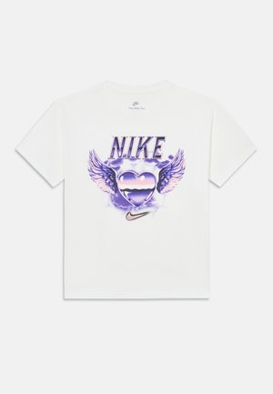Hvit Nike T-skjorte med lilla grafikk av et hjerte med vinger, lyn i bakgrunnen, ordet "NIKE" over, og Nike swoosh-logoen under.