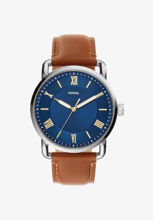 Montre ronde en argent Fossil avec cadran bleu, chiffres romains dorés, trois aiguilles dorées et bracelet en cuir marron.