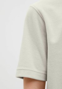 Ljusgrå bomull T-shirt med mjuk textur, korta ärmar med sömda fållar och en avslappnad passform.