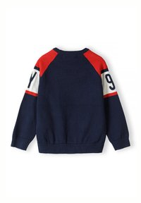 Pull en maille bleu marine avec des accents rouges et blancs, présentant un design raglan et un grand numéro "9" sur la manche gauche. Texture douce.