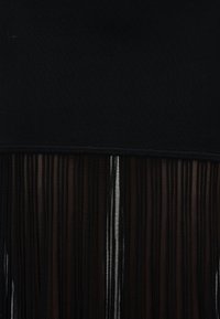 Μαύρο ύφασμα με κάθετες ημιδιαφανείς ρίγες από διαφανή οργαντζίνα κάτω από μια συμπαγή μαύρη λωρίδα, που δείχνει αντίθεση μεταξύ αδιαφανούς και διαφανούς υφής.