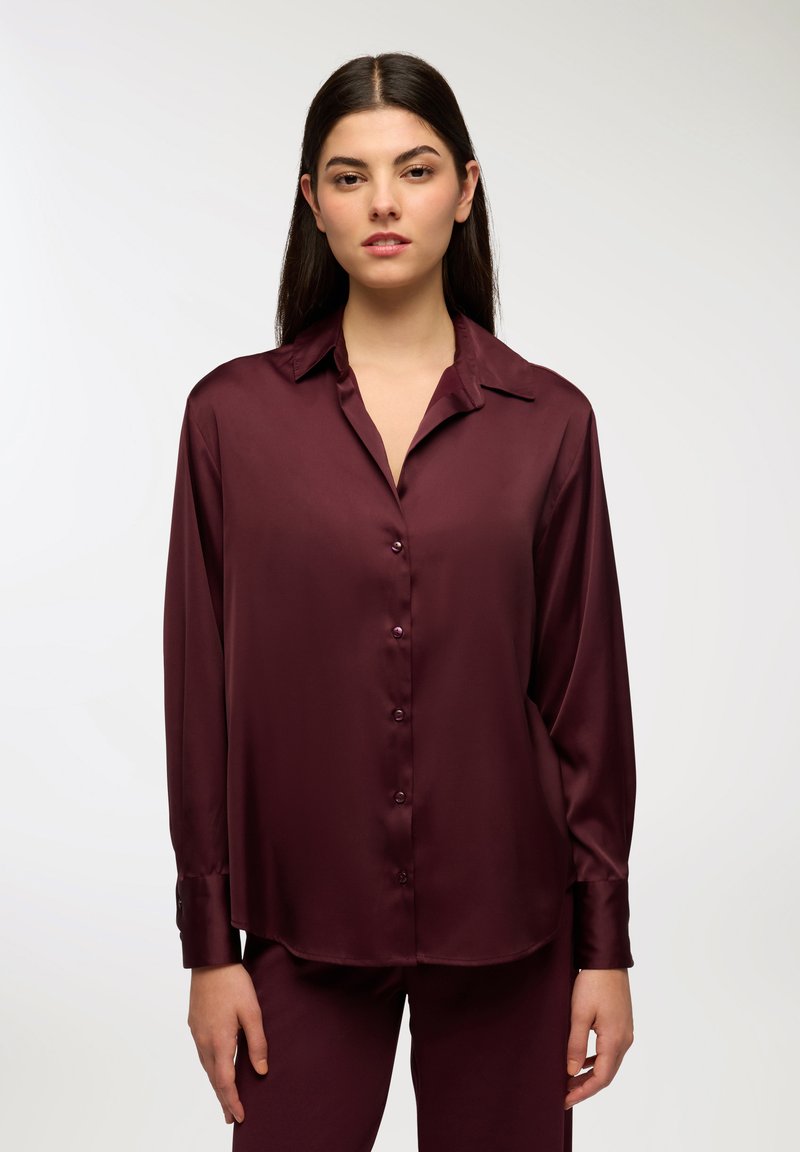 Burgundowa jedwabna koszula z kołnierzykiem, długimi rękawami i guzikami z przodu. Gładka tekstura i luźny krój, uzupełniający pasujące spodnie.