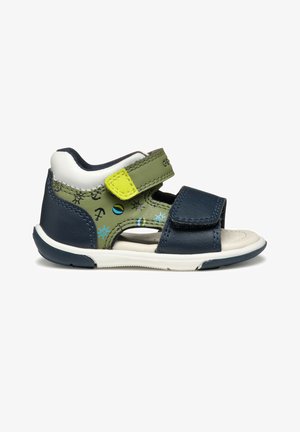Sandale pour enfant en bleu marine et vert olive avec semelle blanche, motifs nautiques bleus, et deux brides réglables en velcro.