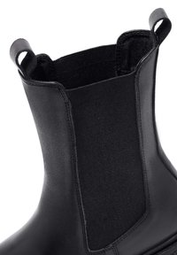Czarne botki Chelsea z elastycznymi panelami bocznymi, wykonane z gładkiej skóry, z pętlami na górze. Solidna podeszwa z zaokrąglonym noskiem.