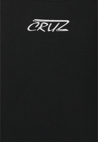 T-shirt noir à col rond, fabriqué en tissu lisse. Présente le texte blanc "CRUZ" près de l'encolure dans une police stylisée.
