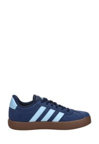 Niedriger Sneaker in Marineblau mit hellblauer Fersenschlaufe und Streifen, brauner Gummisohle und schwarzen Schnürsenkeln.
