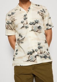 Korte mouwen, crèmekleurig Hawaiiaans shirt met print van palmbomen en surfplanken, voorzien van knoopsluiting en een ontspannen fit. Soepele stoftextuur.