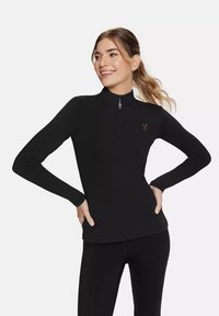 Crni dugi rukav sportski top s četvrtastim zip-om, s malim zlatnim logotipom na grudima. Glatka tekstura s uskim siluetom.