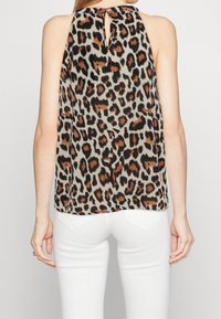 Top senza maniche con stampa leopardata nei toni beige, nero e marrone, caratterizzato da un design con apertura a chiave sul retro. Tessuto leggero con una silhouette fluida.