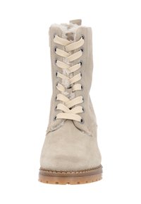 Bottine en suede beige avec une finition texturée, dotée d'une doublure en fourrure, d'un bout arrondi et de lacets beiges enfilés à travers des œillets en métal.