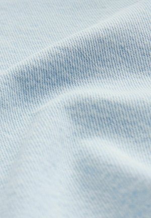 Tissu en denim bleu clair présentant une texture lisse avec de fines côtes horizontales et de légères variations de teinte.