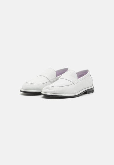 Valged nahast loafersid sileda tekstuuriga, millel on õmmeldud detailid ja minimalistlik disain, mida täiustab must tall.