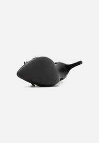 Black high-heeled shoe with a pointed toe, made from smooth material. Features a textured surface and a thin heel for stability.