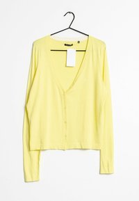 Žlutý kardigan s dlouhým rukávem, výstřihem do V, zapínáním na knoflíky a malým logem. Lehká texturovaná látka s neformálním střihem.
