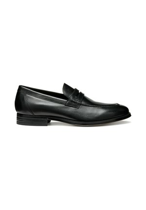 Mocasín de cuero negro con un acabado liso, un tacón bajo apilado y una banda decorativa en la parte superior. Presenta una punta redondeada y detalle de costura.