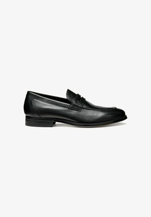 Mocassin en cuir noir avec une finition lisse, un petit talon empilé et une bande décorative en haut. Présente un bout arrondi et un détail de couture.