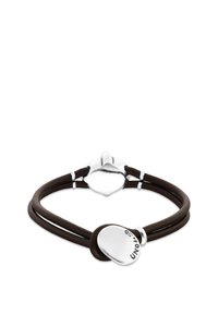 Bracelet double bande en cuir marron avec un charm en forme de cœur en argent poli, comportant un logo gravé et des accents métalliques.