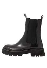 Schwarze Leder-Chelsea-Stiefel mit elastischen Seitenpaneelen, abgerundeter Spitze und dickem, strukturiertem Gummisohle. Betonte Nahtverarbeitung entlang der Nähte sichtbar.
