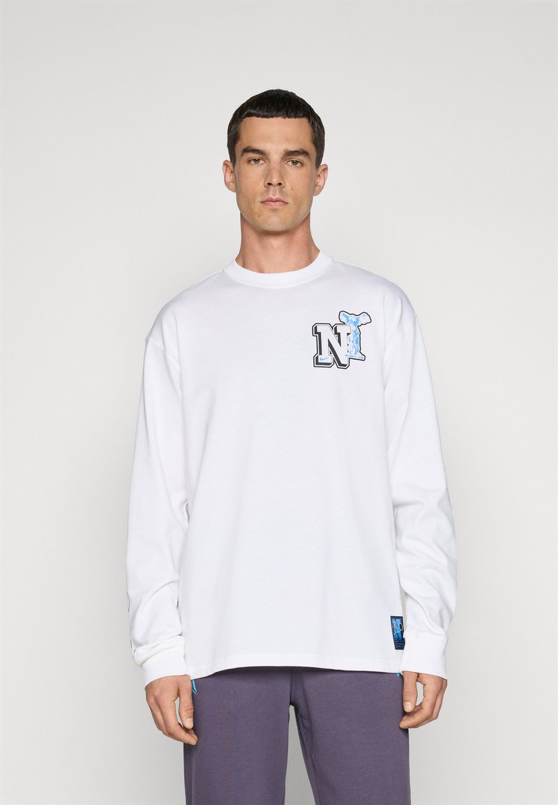 T-shirt blanc à manches longues en coton avec un design graphique représentant la queue d'une baleine bleue et la lettre 'N' à l'avant.