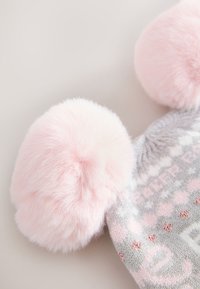 Gestrickte Mütze in Grau mit pinken Bommel, mit einem geometrischen Muster. Hergestellt aus weichem Material, mit einer insgesamt strukturierten Oberfläche.