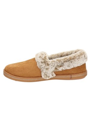 Bruine suède slipper met een zachte nep bont manchet. Kenmerkt zich door een vlakke zool en gestikte accenten langs de rand. Eenvoudig en gezellig ontwerp.