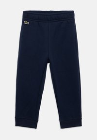 Tumši zili bērnu sporta bikses ar elastīgu jostasvietu, ribotu potīšu malām un mazu zaļu krokodilu logo netālu no kreisās kabatas.