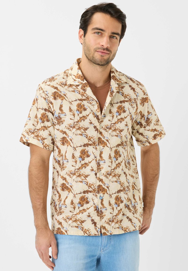 Camicia a maniche corte realizzata in tessuto leggero, con una base beige decorata da motivi floreali marroni e blu, e un colletto stile camp.