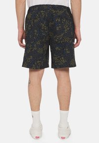 Pantaloncini corti di colore blu navy con un motivo floreale verde e blu. Presentano una vita elastica e due tasche posteriori. Il tessuto appare leggero.