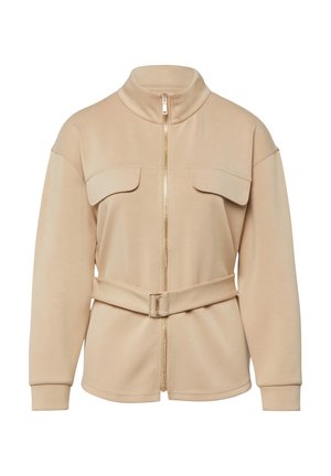 Beige Langarmjacke mit Frontreißverschluss, zwei Brusttaschen mit Klappen, Stehkragen und passendem Gürtel mit rechteckiger Schnalle.