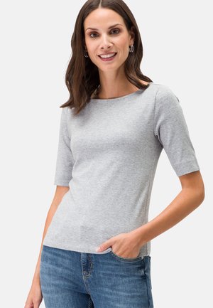 Helles graues T-Shirt mit kurzen Ärmeln aus weichem Stoff, mit rundem Halsausschnitt und figurbetontem Schnitt. Getragen mit blauen Jeans.