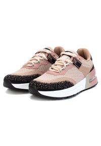 Des baskets en maille rose clair et noire avec une tige texturée, un col rembourré et une semelle intermédiaire blanche avec un amorti à air transparent. Les lacets sont bleu clair.