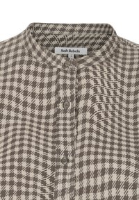 Col de chemise et patte de boutonnage avec motif pied-de-poule marron et beige, tissu doux et étiquette de marque « Soft Rebels » taille small.