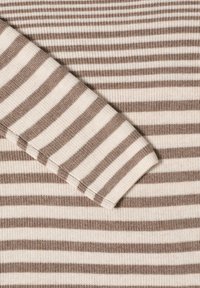 Pull en tricot avec des rayures horizontales dans des teintes crème et marron. Tissu texturé avec des poignets et un ourlet côtelés, mettant en avant un design léger.