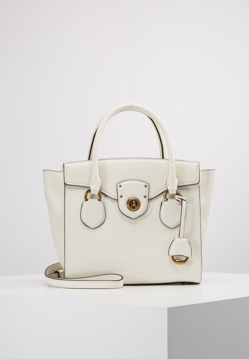 Biała skórzana torebka o strukturalnym designie, z zaokrąglonymi uchwytami, złotymi okuciami, zapięciem na zatrzask i odpinanym paskiem. Posiada akcentujące szwy.