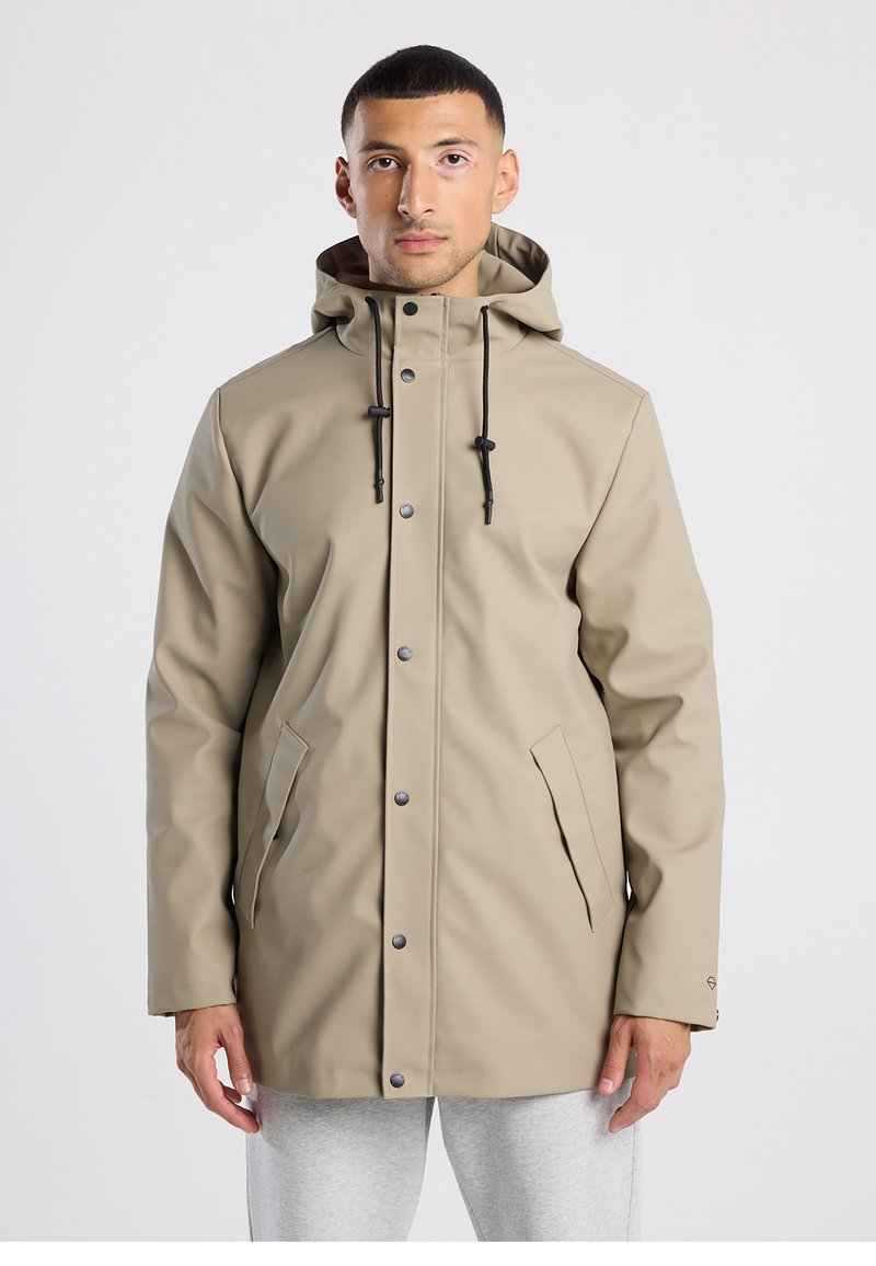 Beige waterproof coat with a hood, featuring a front zipper, snap buttons, and side pockets. Smooth texture with adjustable drawstring.