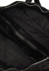 Interno della borsa nera caratterizzato da pelli lisce e tessuti in satin, con una tasca centrale con zip e foderato in tessuto nero, il tutto in un design elegante.