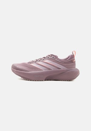 Lilla Adidas løbesko med polstret sål, snørelukning, åndbart mesh-overdel og lyserøde accenter på striberne og hælkappen.