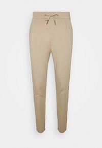 Beige tapered sweatpants med elastisk midja och dragsko, med sidfickor och en slim fit-design.